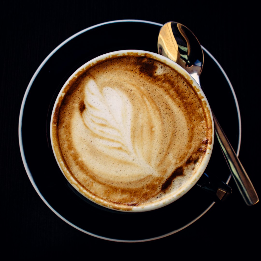 Intricate rosetta latte art in a ceramic cup at Kindling Coffee