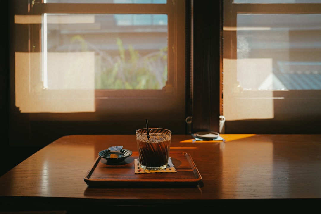 Warm morning sunlight streaming through the cafe windows onto wooden tables