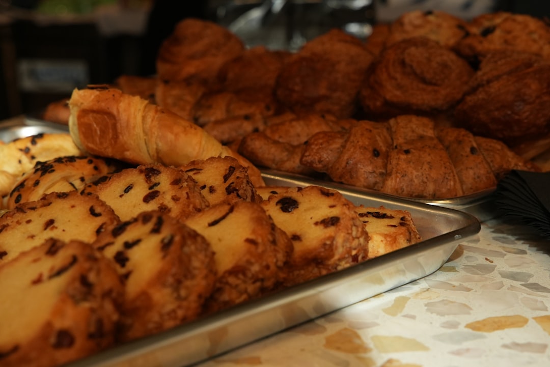 Fresh morning buns and almond croissants displayed on the pastry shelf
