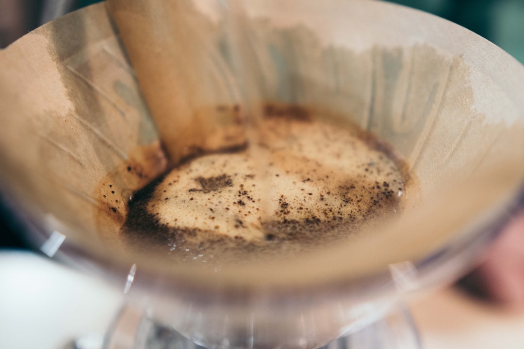 Barista carefully pouring water over a Kalita Wave pour-over dripper at the cafe bar