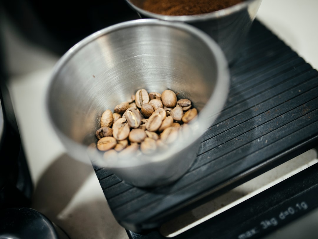 Freshly roasted coffee beans tumbling from a vintage Probat roaster drum in warm amber light